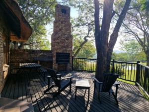 a deck with chairs and a brick chimney with a fireplace at Kruger Park Lodge - Private Villa 514 in Hazyview