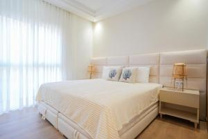 una camera da letto bianca con un letto grande e una finestra di Taghazout Serenity a Tamraght Ouzdar