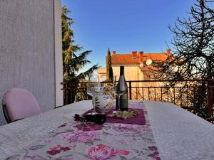 a table with a bottle of wine and a glass at Apartments Katarina in Malinska