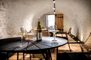 a bottle of wine sitting on a table with wine glasses at Bandi Weekend House in Somlójenő