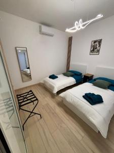 Un dormitorio con dos camas y un espejo. en HOME N & C Noemi & Costa, en Bari