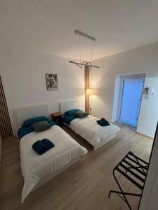 Un dormitorio con dos camas y una lámpara de araña. en HOME N & C Noemi & Costa, en Bari