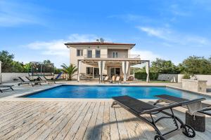 a villa with a swimming pool and a house at Villa Magdalena ZadarVillas in Polača