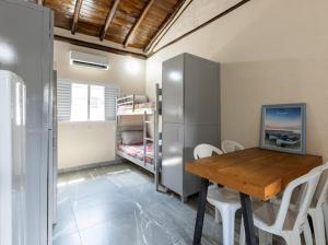 a room with a table and chairs and a bunk bed at Flats Buritis in Dourados