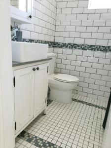 a white bathroom with a toilet and a sink at Great sea view, two room private suite in Kalk Bay in Kalk Bay
