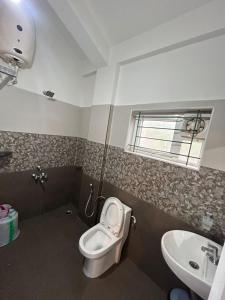 a bathroom with a toilet and a sink at S ELLA Residency in Kotagiri