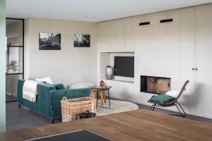 a living room with a green couch and a fireplace at Watertoren in Kortemark