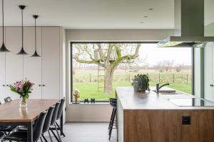 a kitchen with a table and a large window at Watertoren in Kortemark