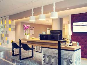 a lobby with a desk with chairs and a computer at Mercure Gdańsk Posejdon in Gdańsk