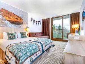 a hotel room with a bed and a large window at Mercure Gdańsk Posejdon in Gdańsk