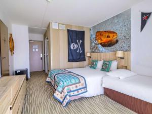 a hotel room with two beds and a painting on the wall at Mercure Gdańsk Posejdon in Gdańsk