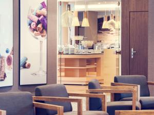 a room with chairs and a table and a kitchen at Mercure Gdańsk Posejdon in Gdańsk