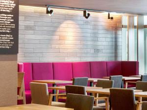 a dining room with tables and pink chairs at Mercure Gdańsk Posejdon in Gdańsk