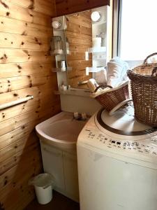 a bathroom with a toilet and a mirror and baskets at chez Petit Lapinシェプチラパン in Karuizawa