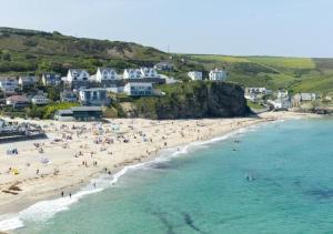 an aerial view of a beach with people in the water at Honeysuckle Cabin in Redruth