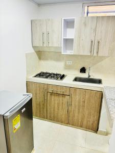 a kitchen with wooden cabinets and a sink and a stove at Apartamento en Taganga in Taganga +8 photos
