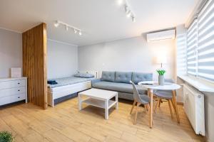 a room with a couch and a table and a bed at Apartament Szczecin - Kobalt Brama Portowa II in Szczecin