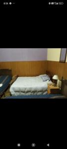 a bedroom with a bed and a table with a lamp at Hotel Cuatro Soles in Mar del Plata