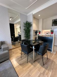 ein Wohnzimmer mit Tisch und Stühlen und eine Küche in der Unterkunft Modern Apartment in Belgrade Waterfront in Belgrad
