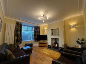 a living room with a couch and a fire place at 1 Lathom Ave - Parking, 2 Bathrooms, Comfortable, Welcoming, Nice Area in Morecambe