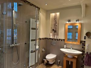 a bathroom with a sink and a shower and a toilet at Fachwerkliebe Ornes 3 in Olsberg