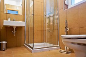 a bathroom with a shower and a toilet and a sink at Völgy Vendégház in Etyek