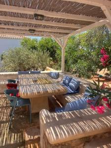 a wooden table and chairs under a wooden pergola at Simos suites in Elafonisos
