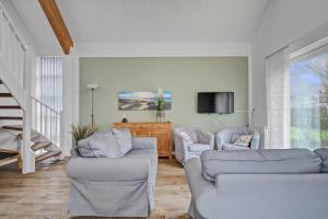a living room with two couches and a tv at Villa Beatrix - Landal park Ooghduyne Julianadorp aan Zee in Bruggenmors