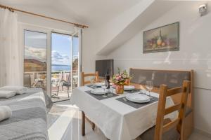 a dining room with a table and a balcony at Villa Mimoza in Baška Voda