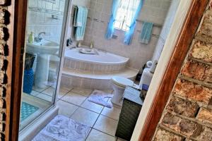 a bathroom with a tub and a toilet and a sink at Boknesstrand Self-catering Accommodation Holiday Home - a Mermaids Cottage minutes to the beach, lagoon, shops & more! in Boknes