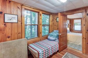 a room with a bench and a bed in a room at Dock, Beach, Views Rustic Green Lake Cottage in Otis