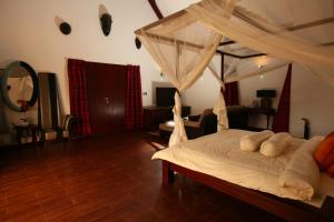 a bedroom with a large bed with a canopy at Villa Raymond, Diani, Kenya in Diani Beach