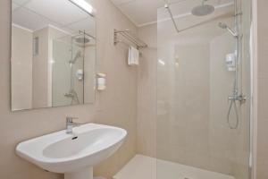 a white bathroom with a sink and a shower at Sunside Ibiza Studios - Only Adults- Formerly known as Central Park in San Antonio