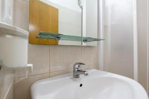 a bathroom sink with a glass shelf above it at Casa Os Manos - Hikers Lodge in Santana +36 photos