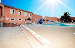un gran patio con piscina y parque infantil en Lovely Home In Le Barcarès With Sauna, en Le Barcarès 23 fotos más