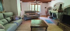 Una sala de estar con dos sofás y una chimenea. en Casa Rural Mantxoalorra, en Ochagavía