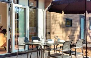 a table with chairs and an umbrella on a patio at 2 Bedroom Lovely Home In Hellendoorn in Hellendoorn +12 photos