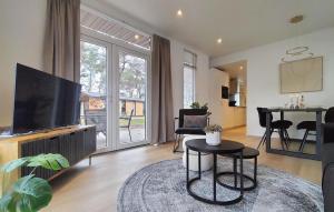a living room with a flat screen tv and a table at 2 Bedroom Lovely Home In Hellendoorn in Hellendoorn