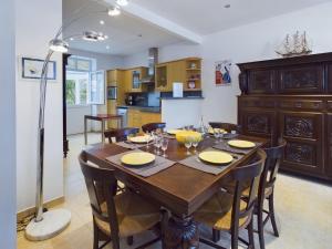 a kitchen and dining room with a wooden table and chairs at À 110 m de la plage, maison pour 6 personnes in Concarneau +12 photos