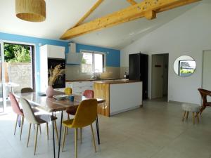 a kitchen and dining room with a table and chairs at Maison 6 avec piscine chauffée à St-Hilaire in Saint-Hilaire-de-Riez