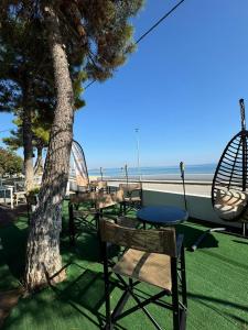 a group of tables and chairs next to the beach at Beach Apartment A in Nea Karvali