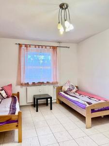 two beds in a room with a window and a table at 3-Zimmer Apartment für Monteure in Hannover in Hannover