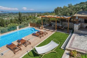 a backyard with a swimming pool with chairs and a table at Villa Clairy 3-Bedroom Villa with Private Pool in Zakynthos