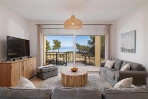 a living room with a couch and a tv at SunBreeze-Beachfront Luxury Villa 5 Bed 4 bath-Sleeps 10 in Potámion