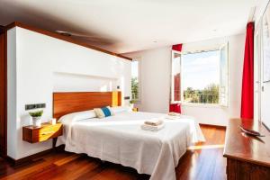 a bedroom with a large white bed and a window at Villa Julianne by Villa Plus in Cala en Blanes +19 photos