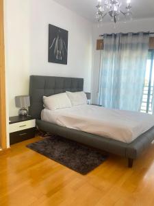 a large bed in a bedroom with a chandelier at Great V4 Villa with Private Salt Pool in Quinta do Anjo +38 photos