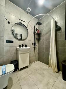 un bagno con lavandino e specchio di ApartPoltava Світлі апартаменти з високою стелею Стильний ДИЗАЙН 2023 a Poltava