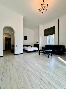 un ampio soggiorno con un letto e un divano di ApartPoltava Світлі апартаменти з високою стелею Стильний ДИЗАЙН 2023 a Poltava