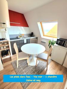 kuchnia ze stołem i krzesłami w pokoju w obiekcie "Mon Évidence!" Magnifique appartement vue mer et accès direct à la plage w mieście Villers-sur-Mer