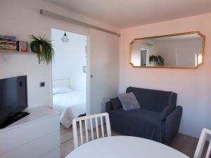 salon z niebieskim krzesłem i lustrem w obiekcie "Mon Évidence!" Magnifique appartement vue mer et accès direct à la plage w mieście Villers-sur-Mer